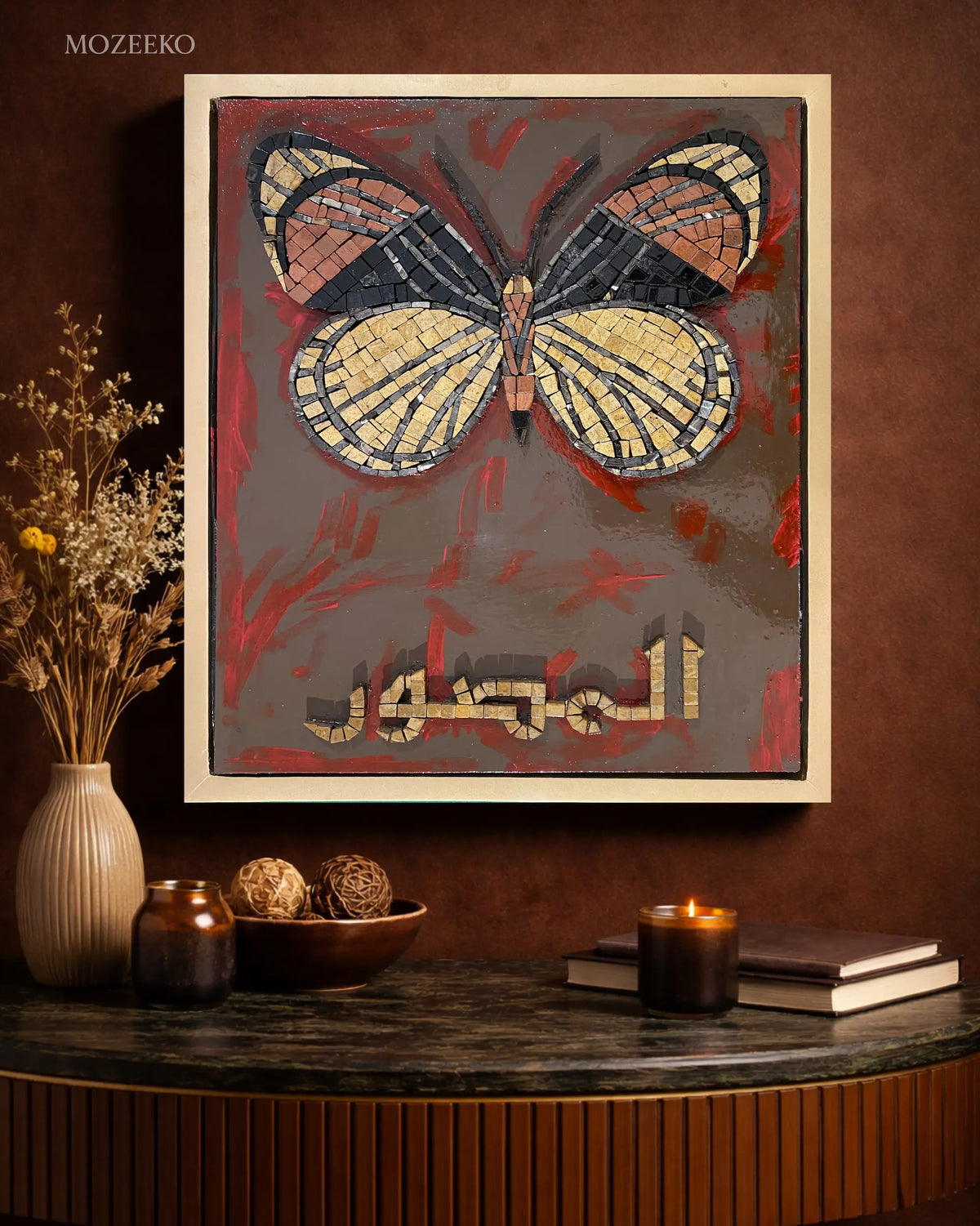Handmade marble mosaic artwork featuring a butterfly motif and Arabic calligraphy Al-Muṣawwir over an abstract acrylic painted background, framed in a golden floating wooden frame by Mozeeko Atelier.