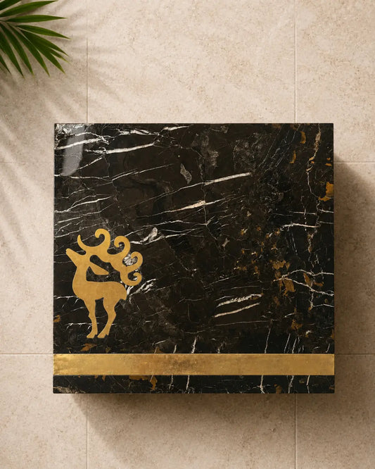Black and gold marble table top with brass stag emblem and wide brass border