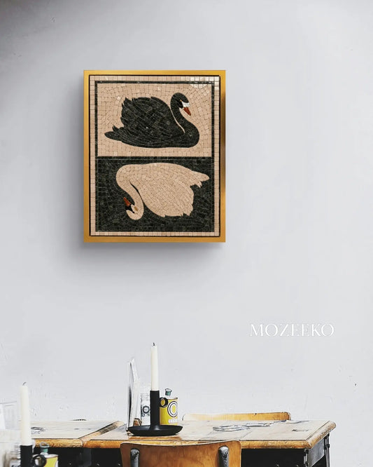 Black and white swans marble mosaic wall art displayed in a golden frame above a dining table.
