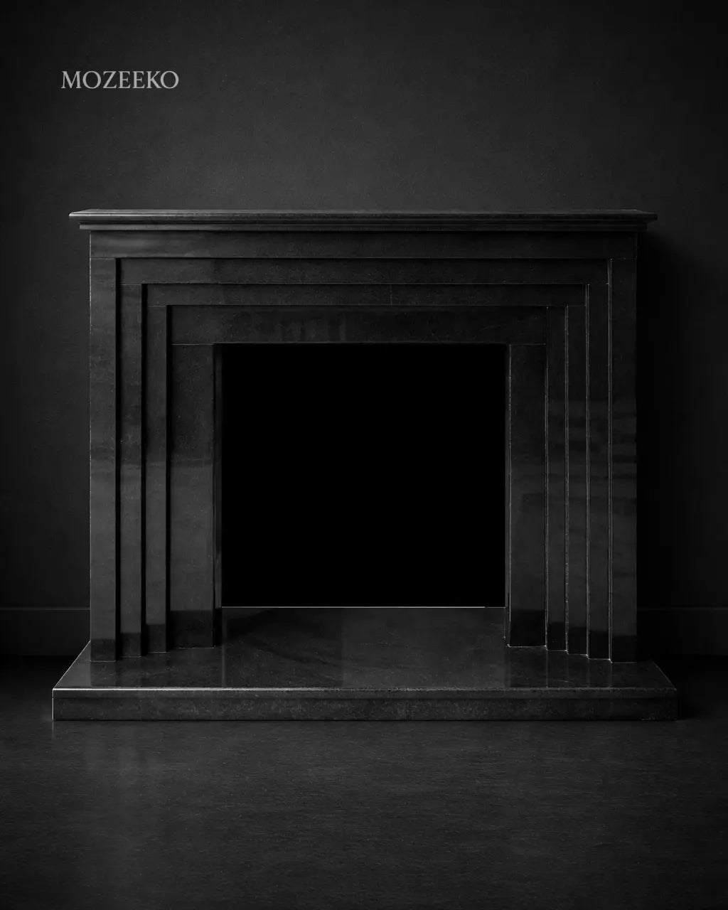 Minimalist jet black granite fireplace with stepped architectural profiles, handcrafted as a modern luxury fireplace by Mozeeko.