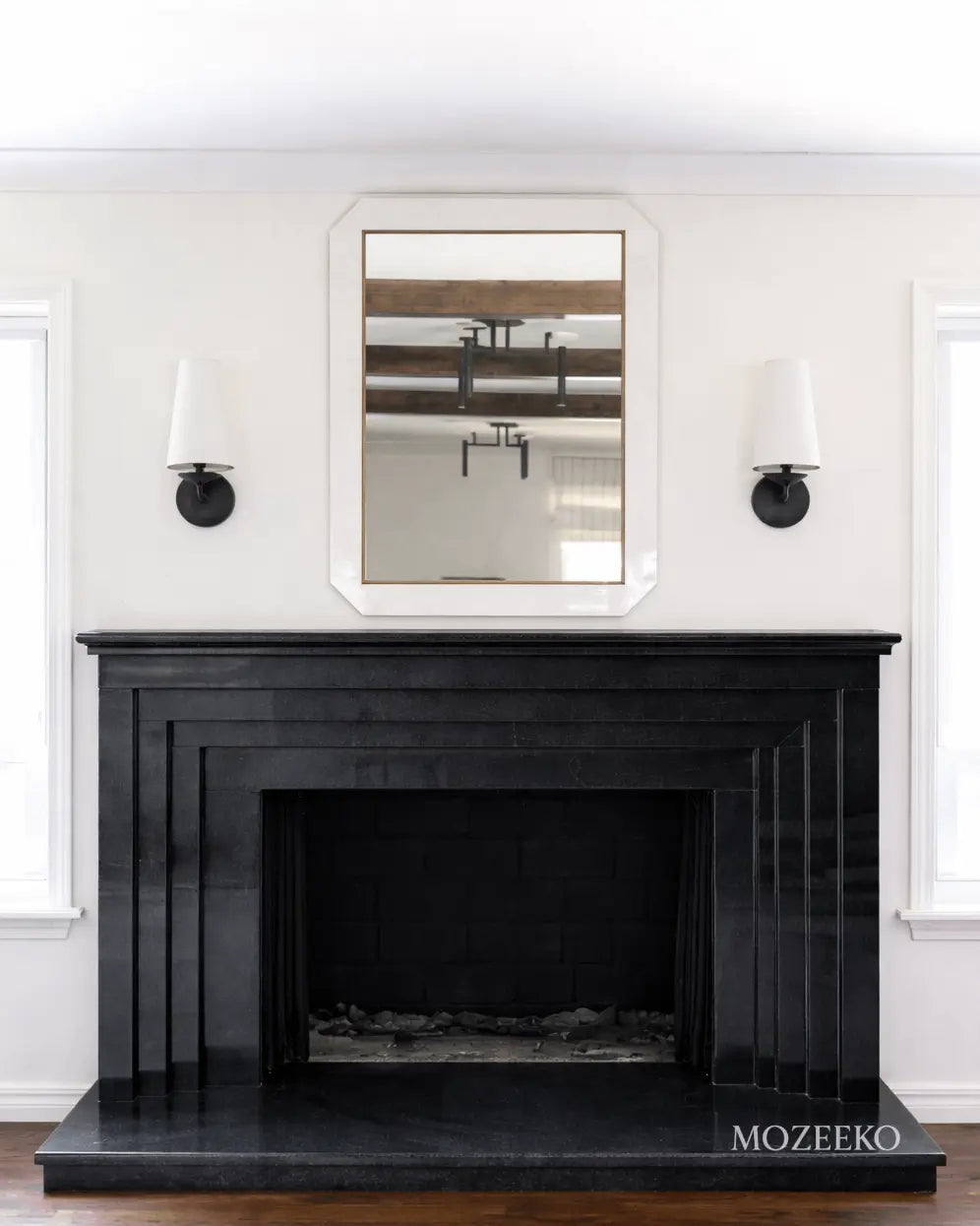 Minimalist jet black granite fireplace with stepped architectural profiles, handcrafted as a modern luxury fireplace by Mozeeko.2