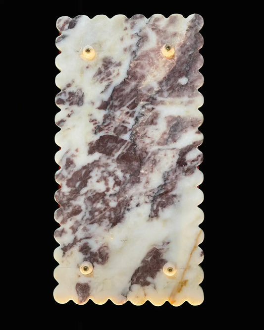 “Back view of red and white marble tray showing white gliders and scalloped edges.”