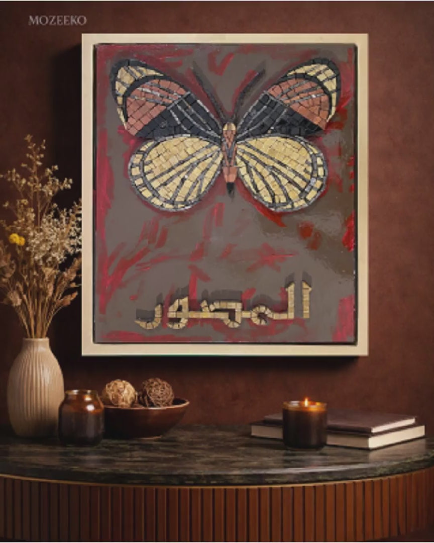 Video showing Al-Muṣawwir marble mosaic wall art with a butterfly motif and Arabic calligraphy over a hand-painted acrylic background, framed in a golden floating wooden frame (18 × 22 inches).