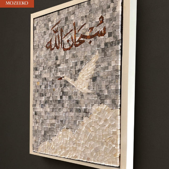 “Video showcasing a handcrafted marble mosaic featuring the Arabic calligraphy ‘Subhan Allah’ above a soaring bird and layered cloud shapes, made from natural stone tiles. The artwork is framed in white, highlighting its calm and timeless spiritual design.”