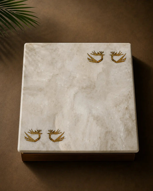 Kamoor White marble table top with hand-inlaid brass birds in flight, photographed from above in a minimal luxury setting.