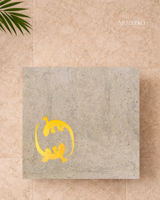 Square travertine table top with brass gecko inlay arranged in a Yin–Yang motif