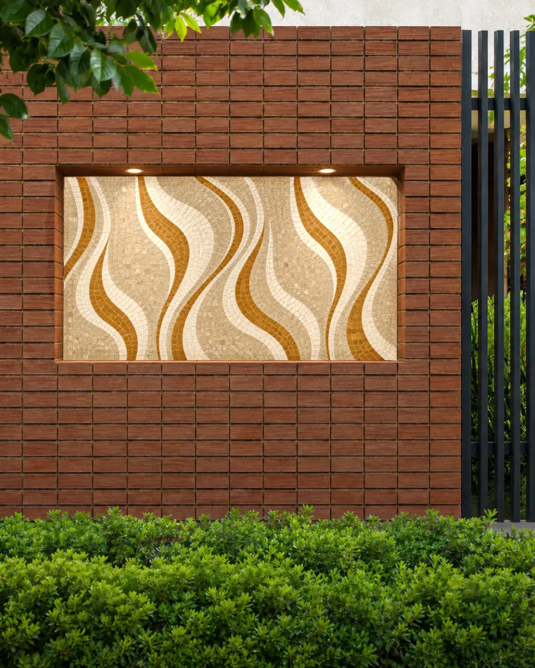 Golden, cream and beige wave-pattern marble mosaic panel installed in an illuminated outdoor brick wall niche